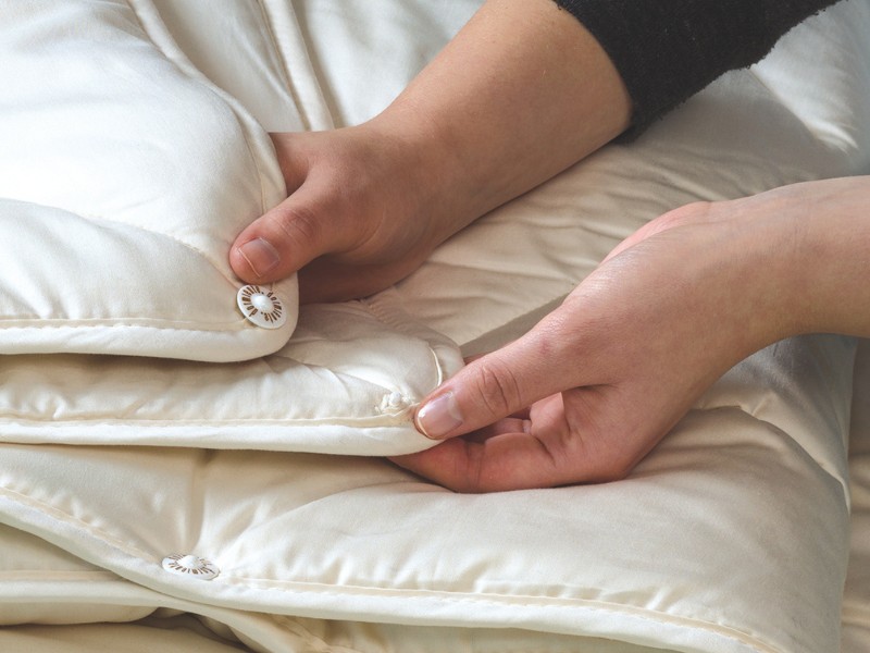 Mit der Knopfverbindung wird aus einer All Season- und einer Sommerdecke eine warme Winterdecke Mit der dormiente-Bettdecken-Knopfverbindung wird aus einer All Season- und einer Sommerdecke eine warme Winterdecke